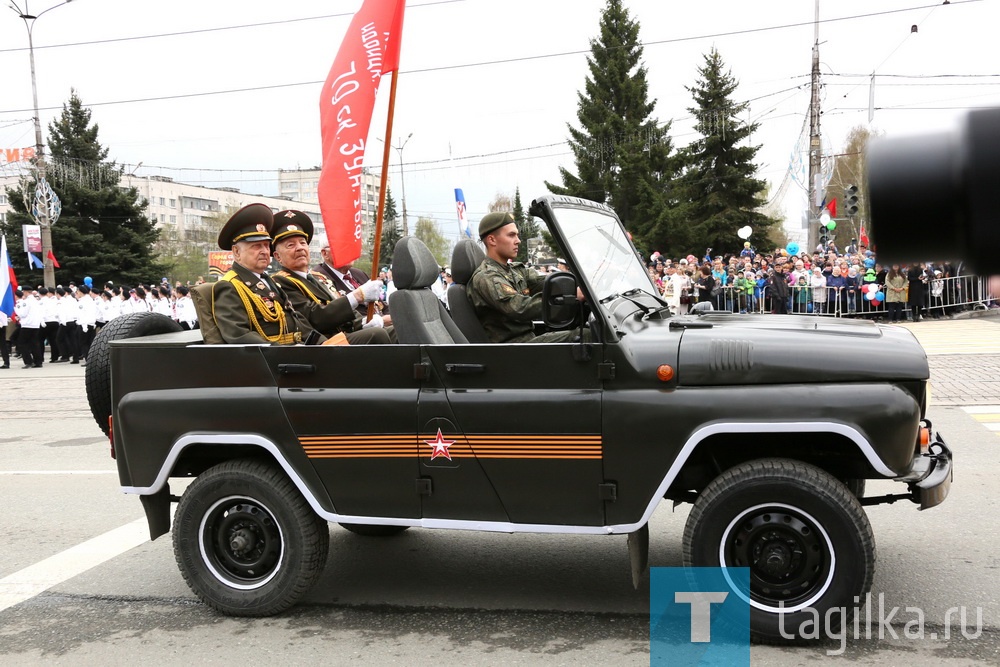 Возглавили колонну боевой техники самые известные знаменосцы Нижнего Тагила – ветераны Великой Отечественной войны Александр Васильевич Федин, Василий Дорофеевич Михайлов и Николай Петрович Анисимов. 

Ветерана Великой Отечественной войны Александра Васильевича Федина в нашем городе знают многие. Он - участник боев Первого Белорусского фронта. В свои 92 года продолжает активную общественную деятельность, принимает участие в патриотических мероприятиях. Сегодня Александр Васильевич в седьмой раз открывает Парады Победы в Нижнем Тагиле. 

В армию Федин пошел в 1943 году в 17 лет. Призывался с Украины, учебную часть окончил в Кунгуре, служил на Первом Белорусском фронте в 27-й гвардейской стрелковой дивизии автоматчиком. Самая памятная для него медаль - «За отвагу». Ее получил за подвиг, совершенный 15 января 1945 года, когда дивизия шла в наступление в районе села Черный лес. В одном из домов немцы устроили пулеметную точку. Александру Васильевичу удалось незаметно подобраться к противнику и швырнуть в дом гранату. Четверо фашистов были убиты наповал, трех взяли в плен. 

Участник Великой Отечественной войны, ветеран Высокогорского горно-обогатительного комбината Василий Дорофеевич Михайлов отправился на фронт в 1943 году. Воевал на 1-м Прибалтийском фронте в инженерно-технических войсках, был огнеметчиком. За годы войны ему довелось участвовать в Белорусской наступательной операции «Багратион», в Витебской наступательной операции, во время которой его фронт первый прорвал оборону противника. В результате этих боев советские войска захватили более 56 тысяч фашистских военнопленных.

В ходе войны ему довелось участвовать в освобождении Латвии, Литвы, Белоруссии и Восточной Пруссии. Василий Дорофеевич помнит, как участвовал в ликвидации Курляндской группировки немецко-фашистских войск, как восемь дней держали оборону, как все это время гудела и дрожала земля. Но самым страшным оказалось освобождение Кенигсберга:

- Мы то уходили в тыл к немцам, то попадали под обстрел и наших, и фашистских орудий. Наконец, под Даугавпилсом прорвали немецкую оборону.

Почетный ветеран города и член совета ветеранов Ленинского района Николай Петрович Анисимов тоже традиционно открывает в Нижнем Тагиле Парад Победы, в этом году, по его словам, уже в восьмой раз. К слову, 9 мая у него двойной праздник: День Победы и день рождения. 

Война застала Николая Петровича, когда он учился в Ленинградском военно-медицинском училище и только перешел на второй курс. 

Ветеран рассказывает, что приближения к войне тогда никто не чувствовал. В роковой день он вместе с другими студентами отправился пешком в летние лагеря. 
- 22 июня мы проходили через Красное Село. И в репродуктор услышали, что сегодня в четыре часа утра без объявления войны немецко-фашистские войска вторглись на территорию Советского Союза. Началась Великая Отечественная война, - рассказывает Николай Петрович. Студентов сначала поставили ловить диверсантов, но вскоре вернули в Ленинград на ускоренное обучение. 

В 18 лет он получил медаль «За боевые заслуги». Это самая дорогая для него медаль, потом были и другие награды, ордена.
